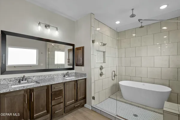 a bathroom with a granite countertop sink a toilet a mirror and bathtub