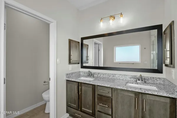 a bathroom with a granite countertop sink and a mirror