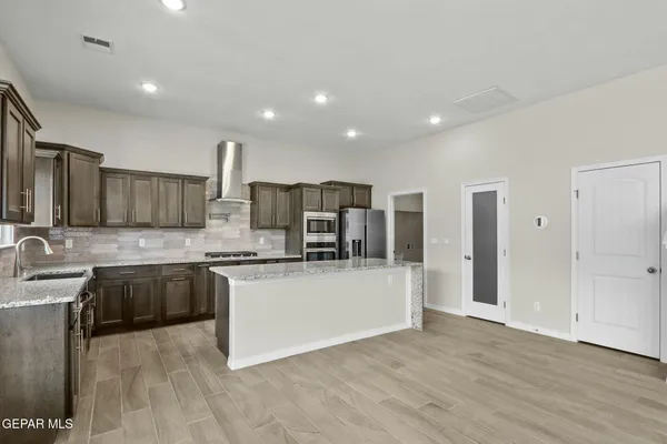 a kitchen with stainless steel appliances granite countertop a sink refrigerator and cabinets