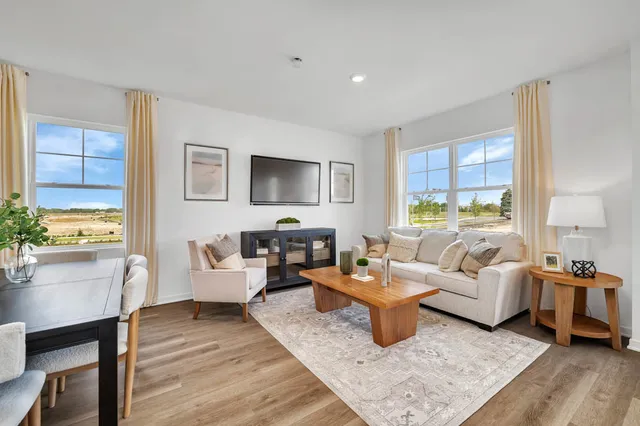 a living room with furniture wooden floor and a window