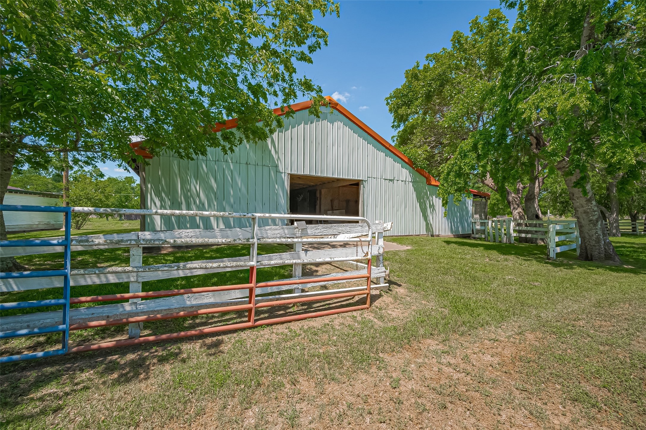 a view of backyard with wooden fence and large trees