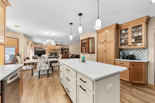 a large kitchen with kitchen island a stove a sink a center island and a wooden floor