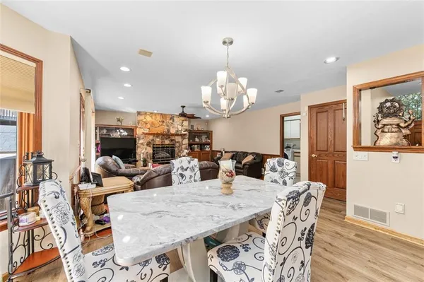 a view of a dining room with furniture a chandelier and wooden floor
