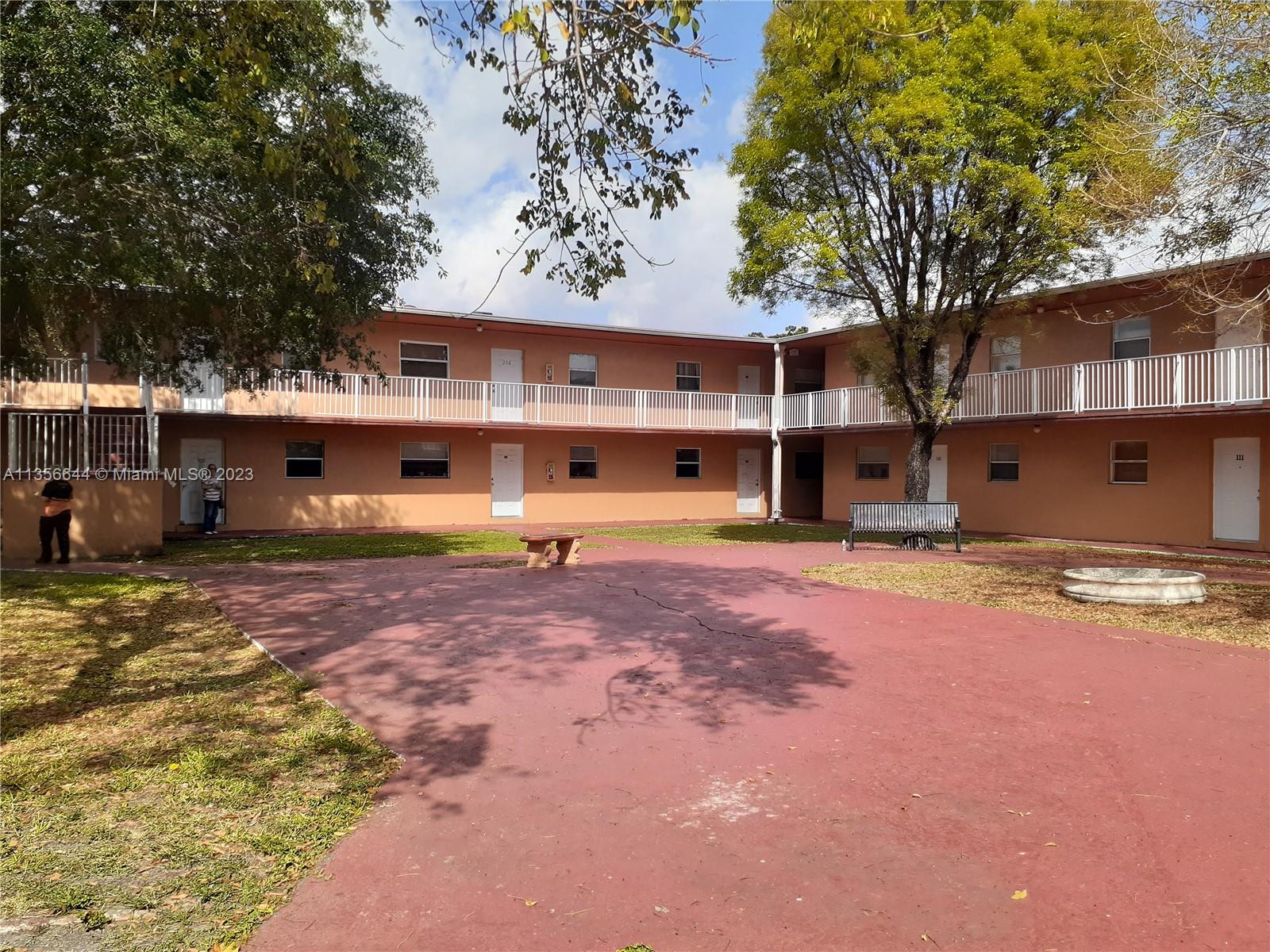 1245 West 24th Street, Unit 118 Hialeah, FL 33010 - Photo 1 of 20 a front view of a house with a yard and garage