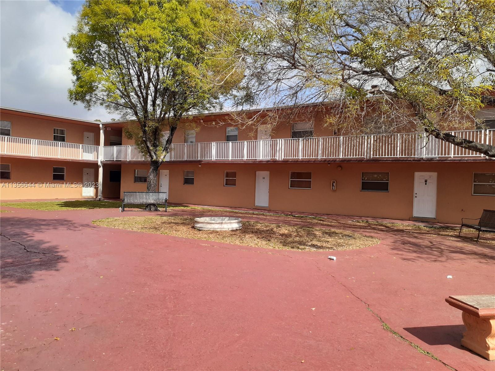 1245 West 24th Street, Unit 118 Hialeah, FL 33010 - Photo 11 of 20 a backyard of a house with yard and large tree