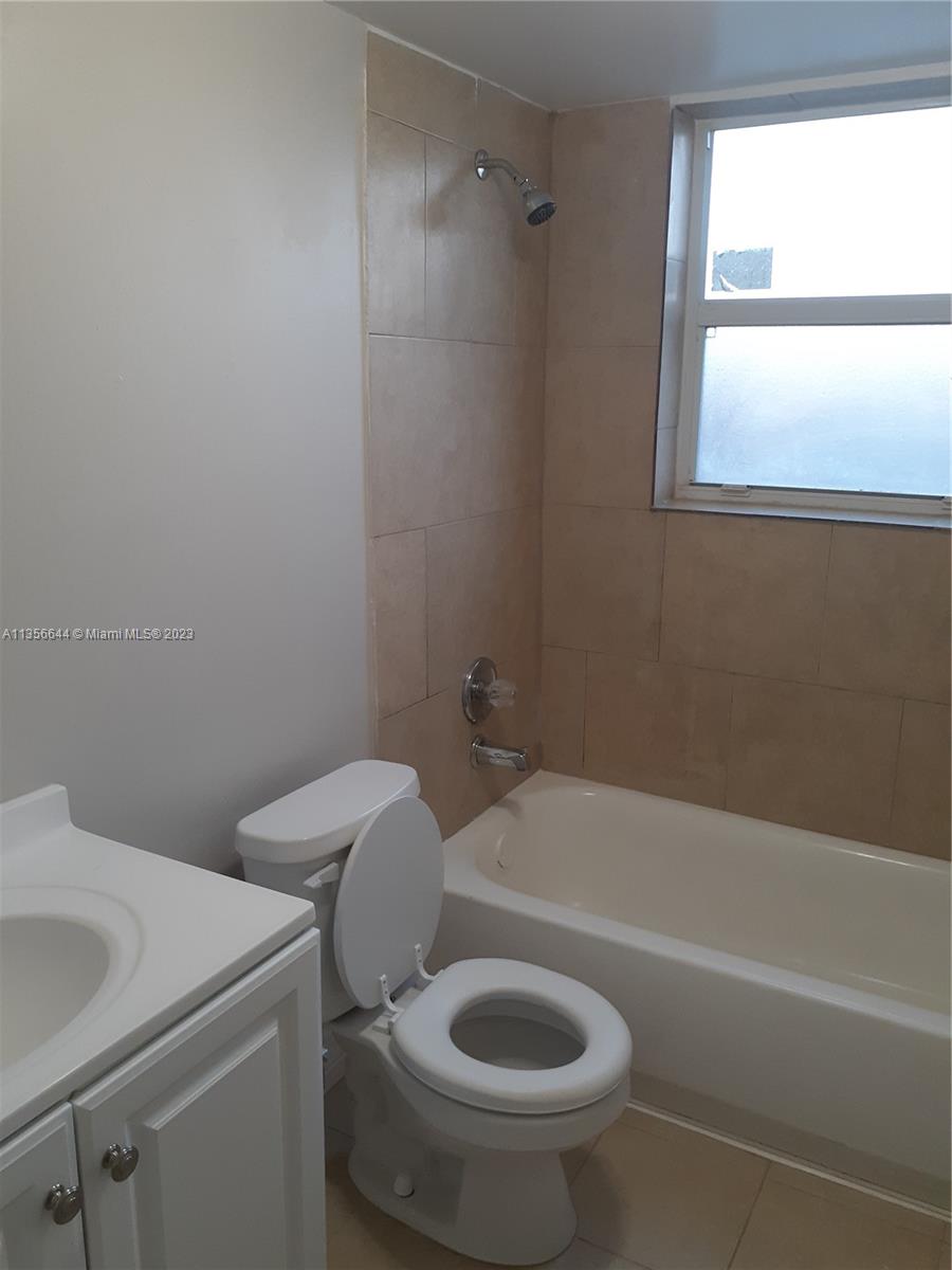 1245 West 24th Street, Unit 118 Hialeah, FL 33010 - Photo 6 of 20 a bath room with a toilet and a bath tub