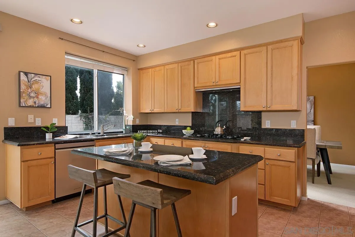 4951 Riding Ridge Road San Diego, CA 92130 - Photo 13 of 32 a kitchen with a sink a counter and chairs