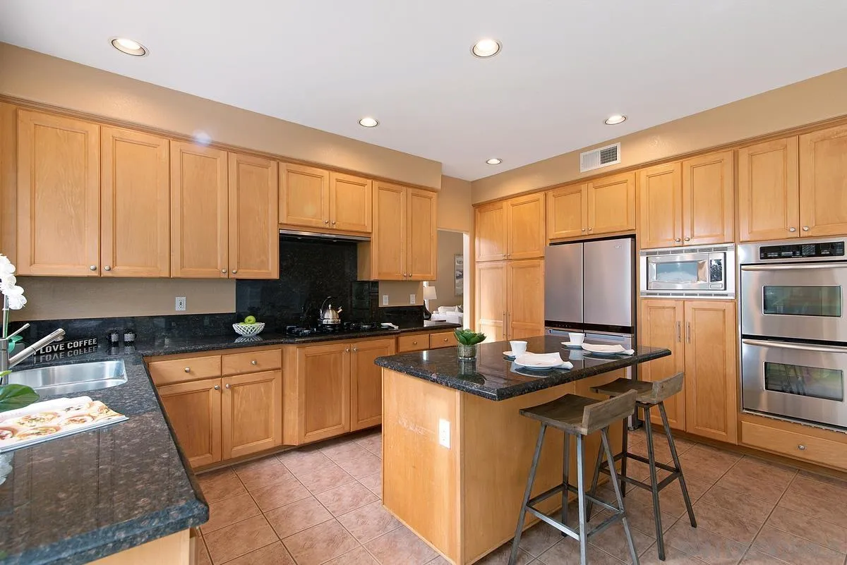 4951 Riding Ridge Road San Diego, CA 92130 - Photo 14 of 32 a kitchen with stainless steel appliances a stove a sink a microwave a refrigerator and cabinets