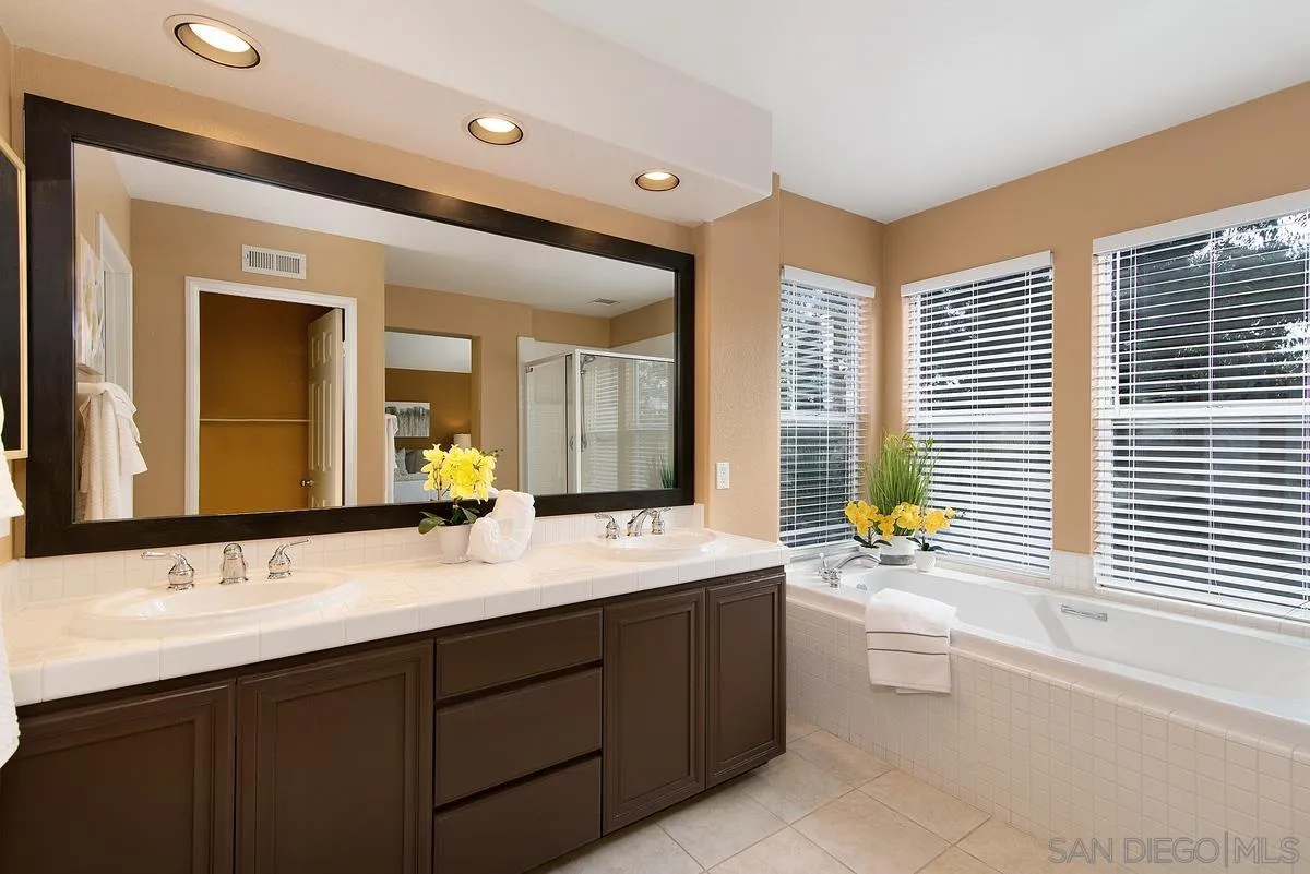 4951 Riding Ridge Road San Diego, CA 92130 - Photo 22 of 32 a bathroom with a sink double vanity mirror and a bathtub