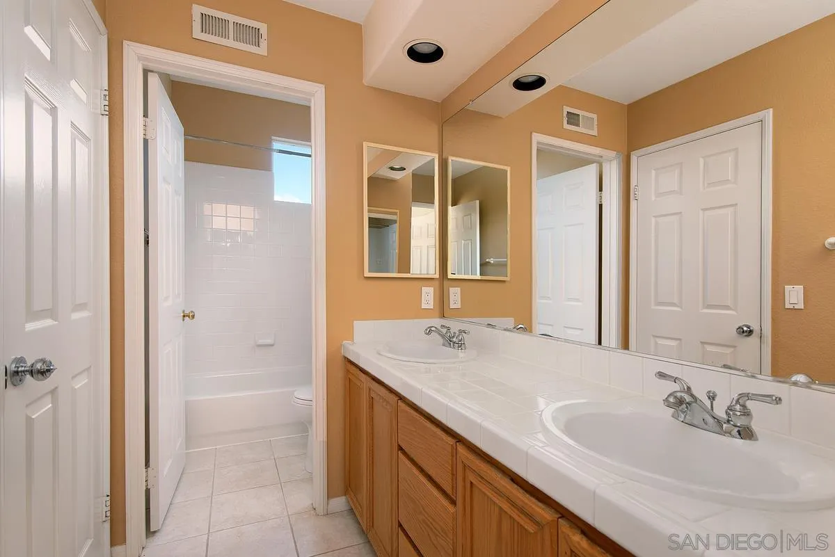 4951 Riding Ridge Road San Diego, CA 92130 - Photo 27 of 32 a bathroom with a sink and a mirror