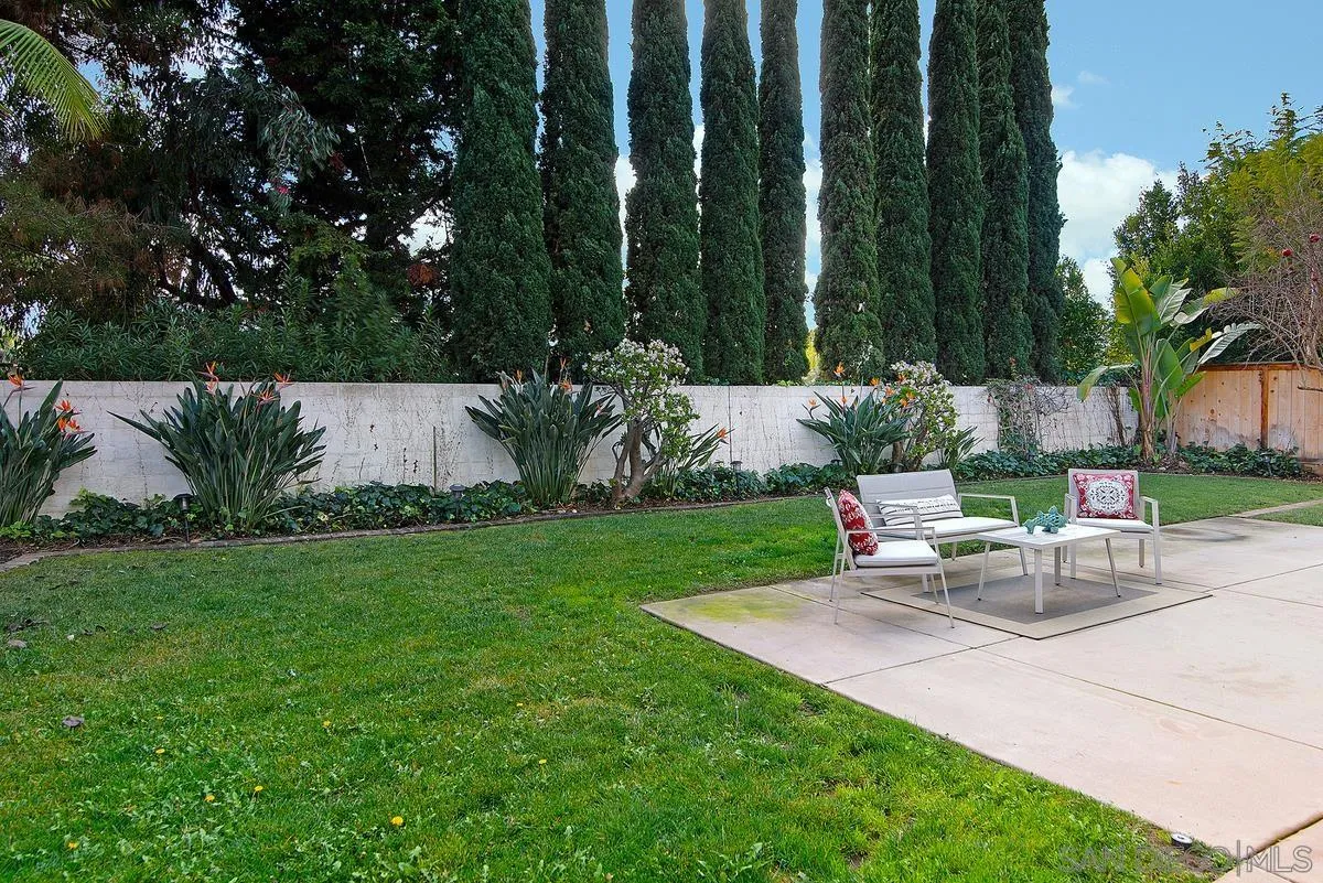 4951 Riding Ridge Road San Diego, CA 92130 - Photo 28 of 32 a view of a backyard with chairs potted plants and large tree