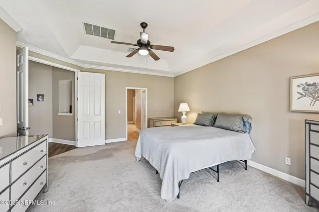 a spacious bedroom with a bed and painting on the wall