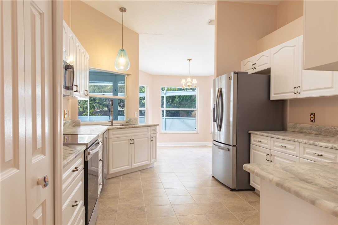 122 Coconut Street Sebastian, FL 32958 - Photo 9 of 36 a kitchen with granite countertop cabinets and refrigerator