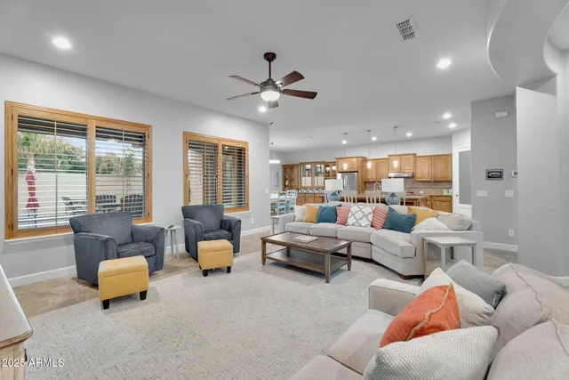 a living room with furniture kitchen view and a chandelier