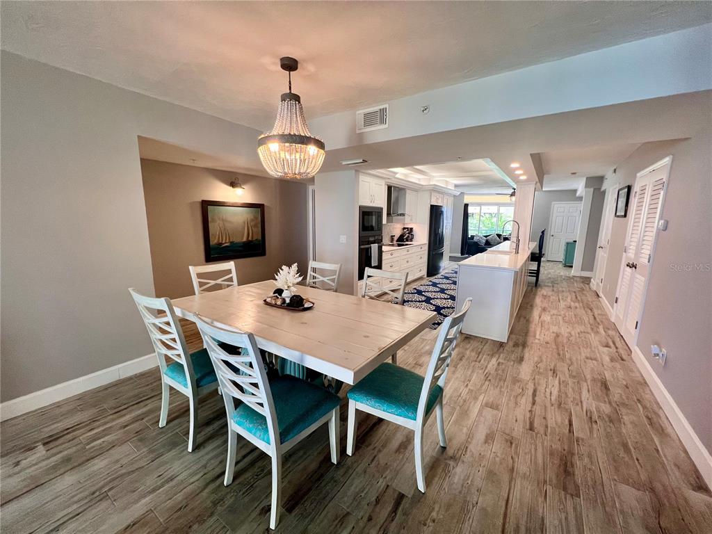 4565 South Atlantic Avenue, Unit 5203 Ponce Inlet, FL 32127 - Photo 12 of 28 a view of a dining room with furniture wooden floor and chandelier