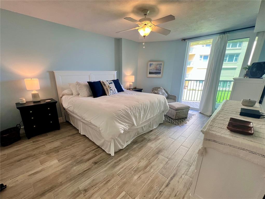 4565 South Atlantic Avenue, Unit 5203 Ponce Inlet, FL 32127 - Photo 14 of 28 a bedroom with a bed a couch and a flat tv screen on dresser