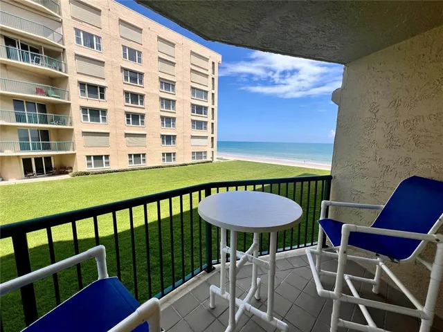 a view of a chairs and table in the balcony
