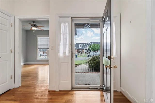 a view of a hallway with wooden floor and a living room