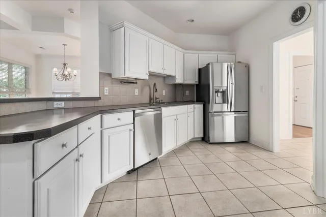 a kitchen with white cabinets a refrigerator and a sink