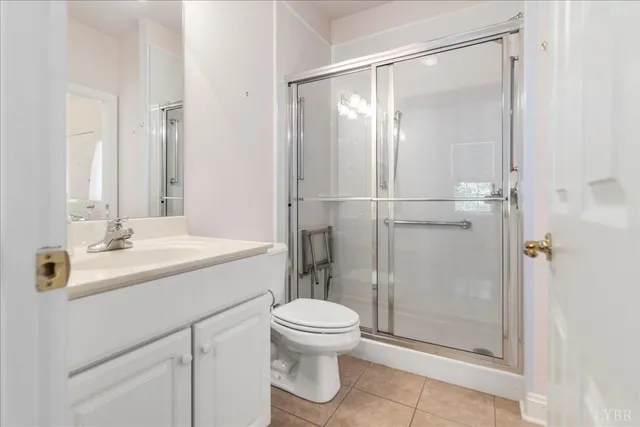 a bathroom with a shower sink vanity mirror and toilet