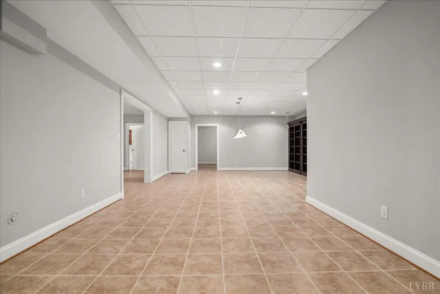 a view of an empty room with window and chandelier