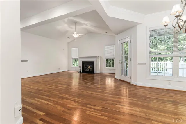 a view of empty room with wooden floor and fireplace