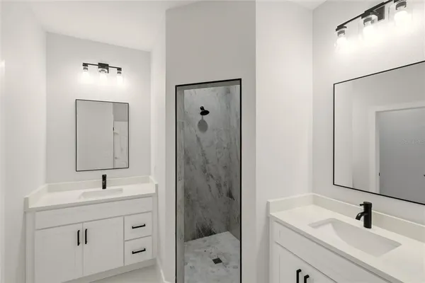 a bathroom with a sink shower and mirror