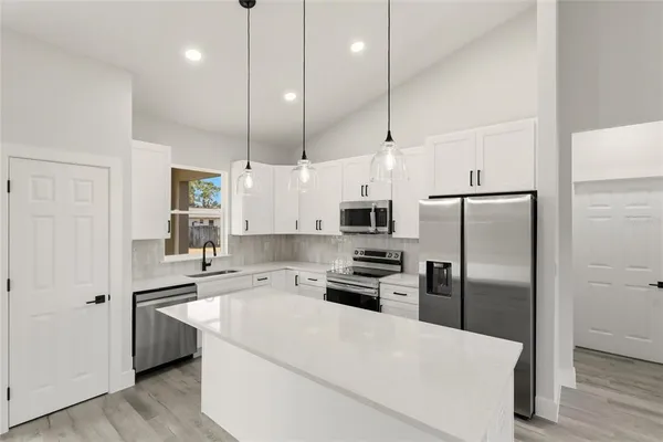 a kitchen with stainless steel appliances a refrigerator sink and stove