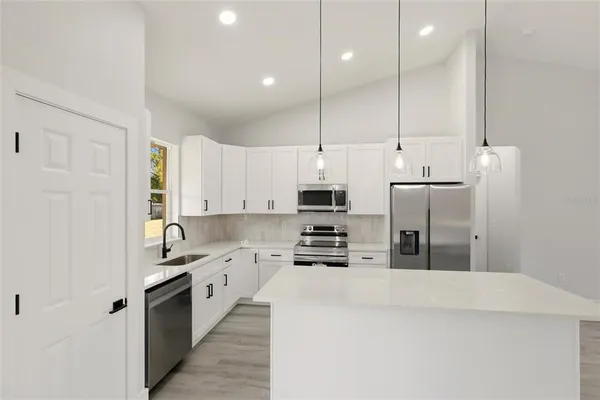 a kitchen with stainless steel appliances a refrigerator sink and cabinets