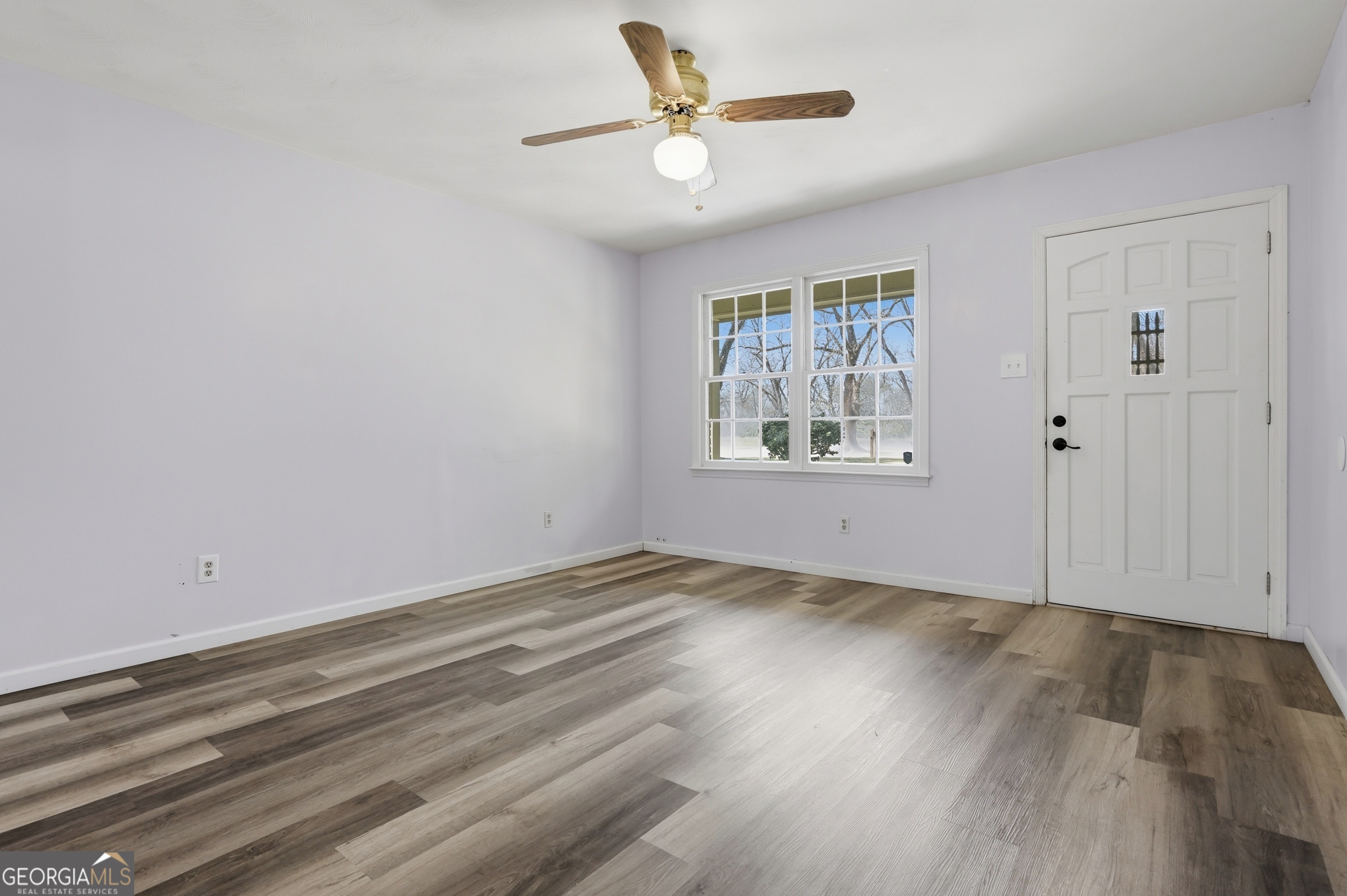 3710 Coakley Avenue Albany, GA 31721 - Photo 13 of 47 an empty room with wooden floor chandelier fan and windows