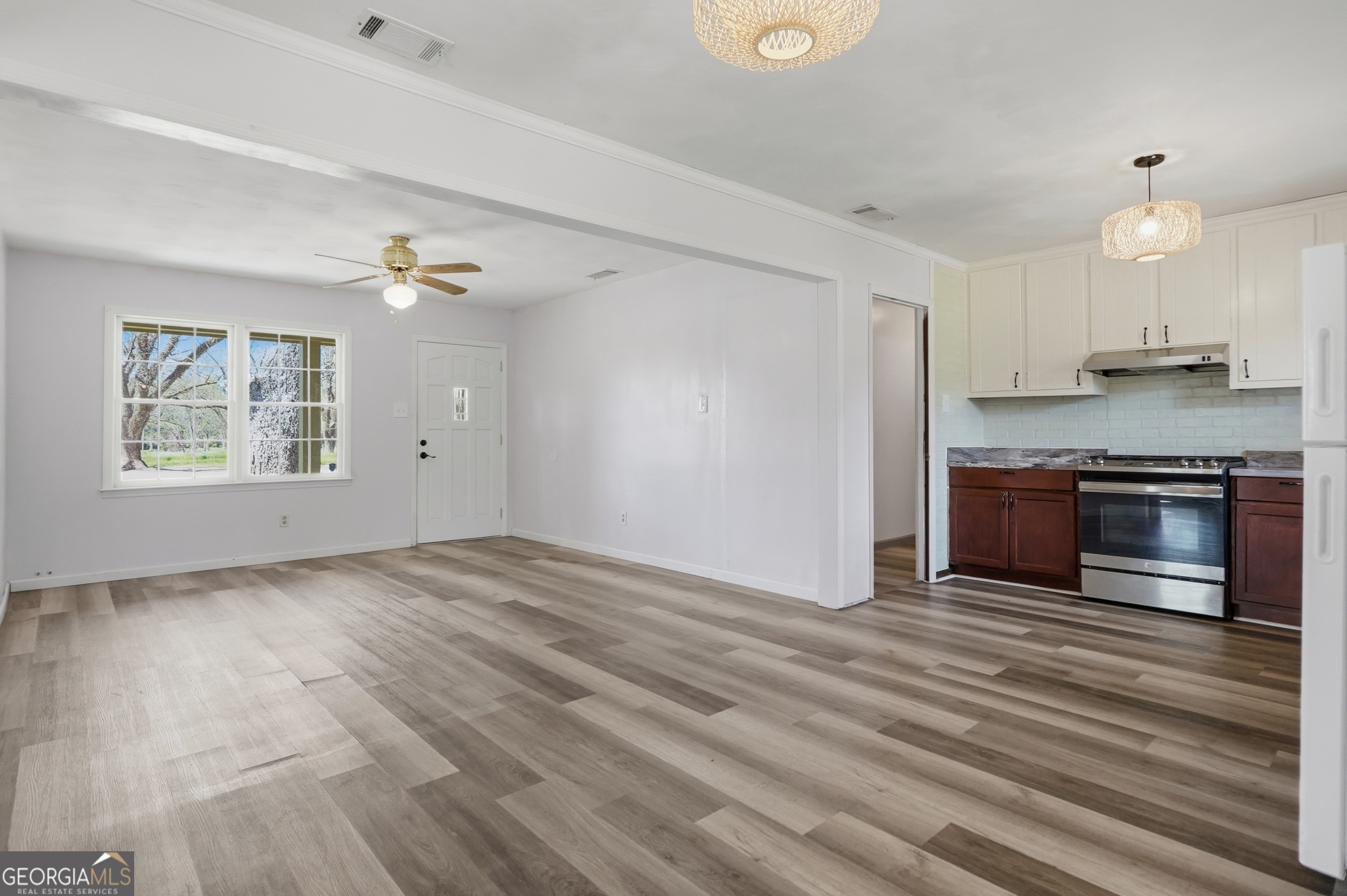 3710 Coakley Avenue Albany, GA 31721 - Photo 14 of 47 an empty room with wooden floor kitchen view and windows