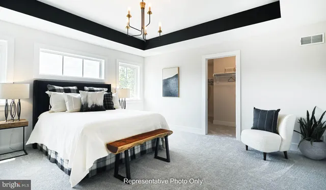 a bedroom with a bed lamp and a chandelier