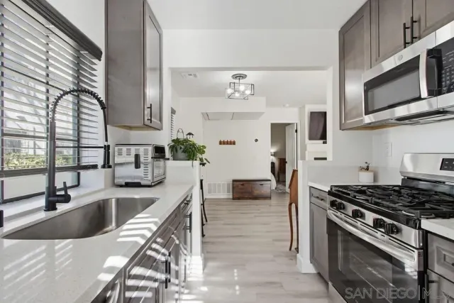 a kitchen with stainless steel appliances a sink a stove and cabinets