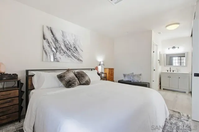 a bedroom with a bed and a painting on the wall