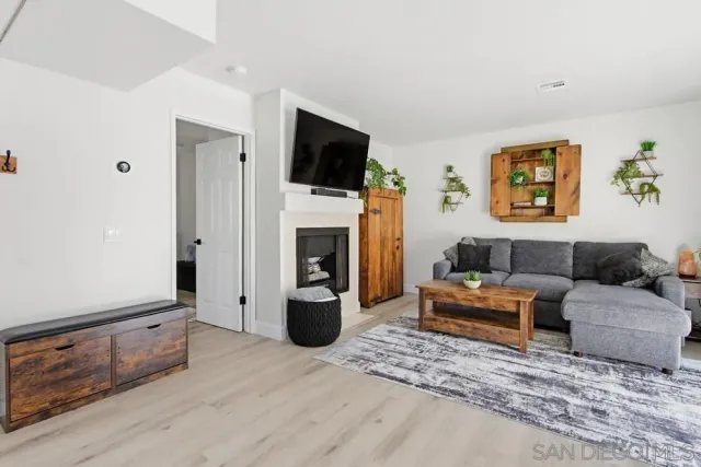a living room with furniture a flat screen tv and a fireplace