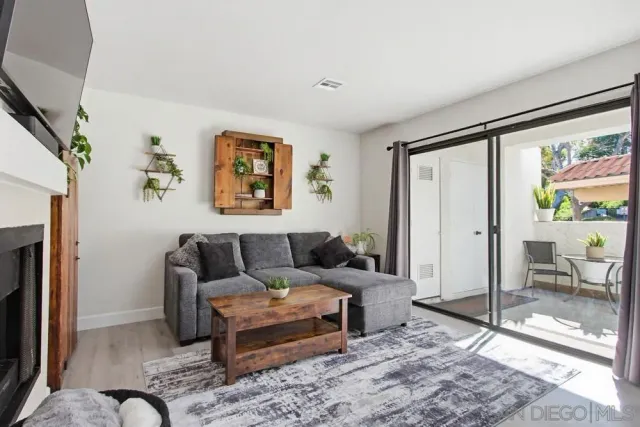 a living room with furniture a rug and wall painting