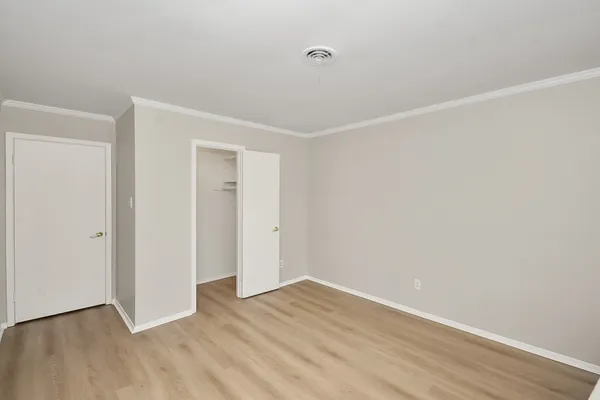 a view of an empty room with wooden floor