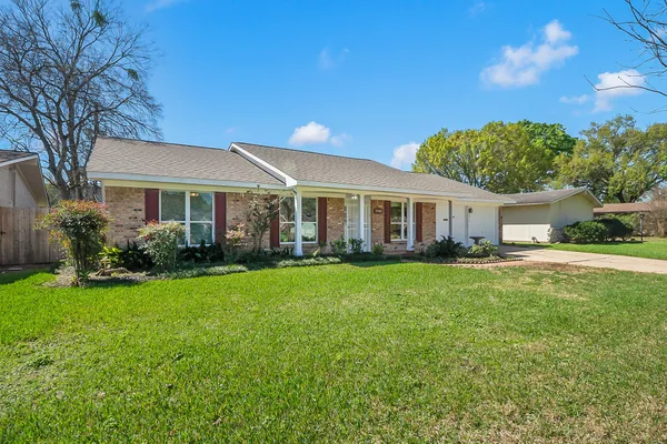 a front view of a house with a yard and green space