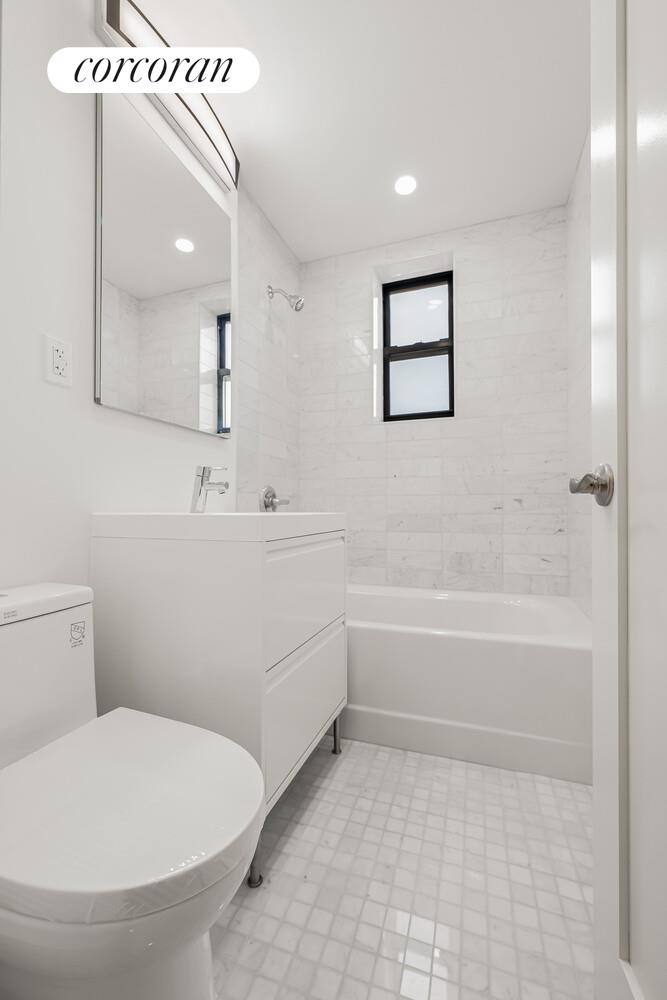 9511 Shore Road, Unit 609 Brooklyn, NY 11209 - Photo 11 of 16 a bathroom with a sink a toilet and a bathtub