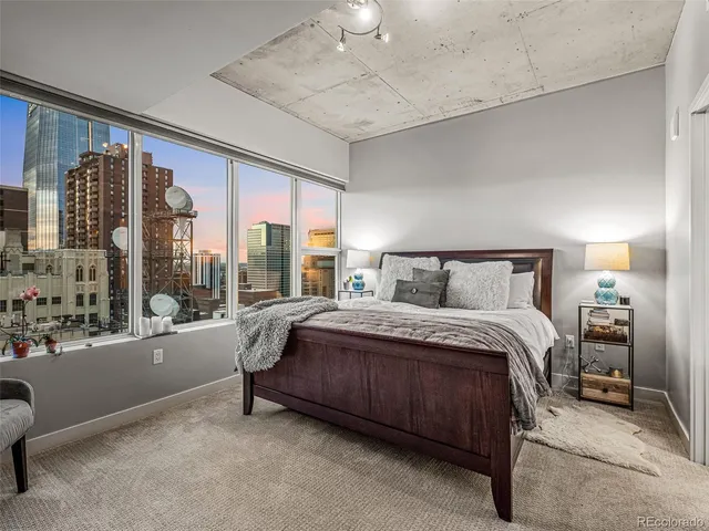 a spacious bedroom with a bed and a large window