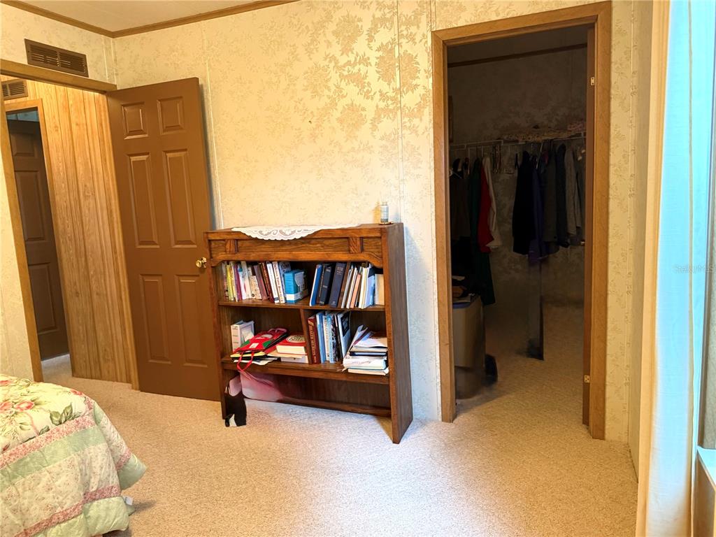 8242 Fiesta Street Brooksville, FL 34613 - Photo 18 of 31 a bedroom with a bed and a book shelf