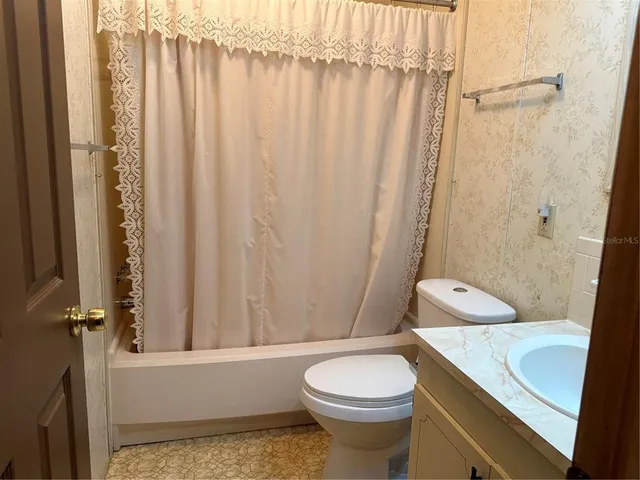 a bathroom with a toilet and a shower curtain
