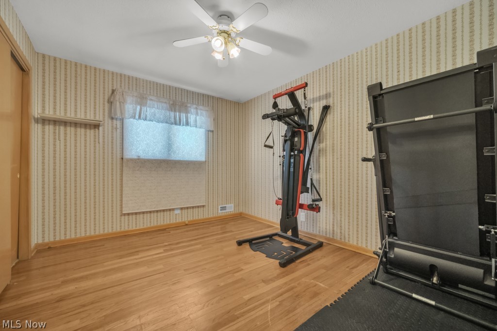 6846 Revere Road Cleveland, OH 44130 - Photo 16 of 30 Workout room featuring light wood-type flooring, a ceiling fan, and wallpapered walls