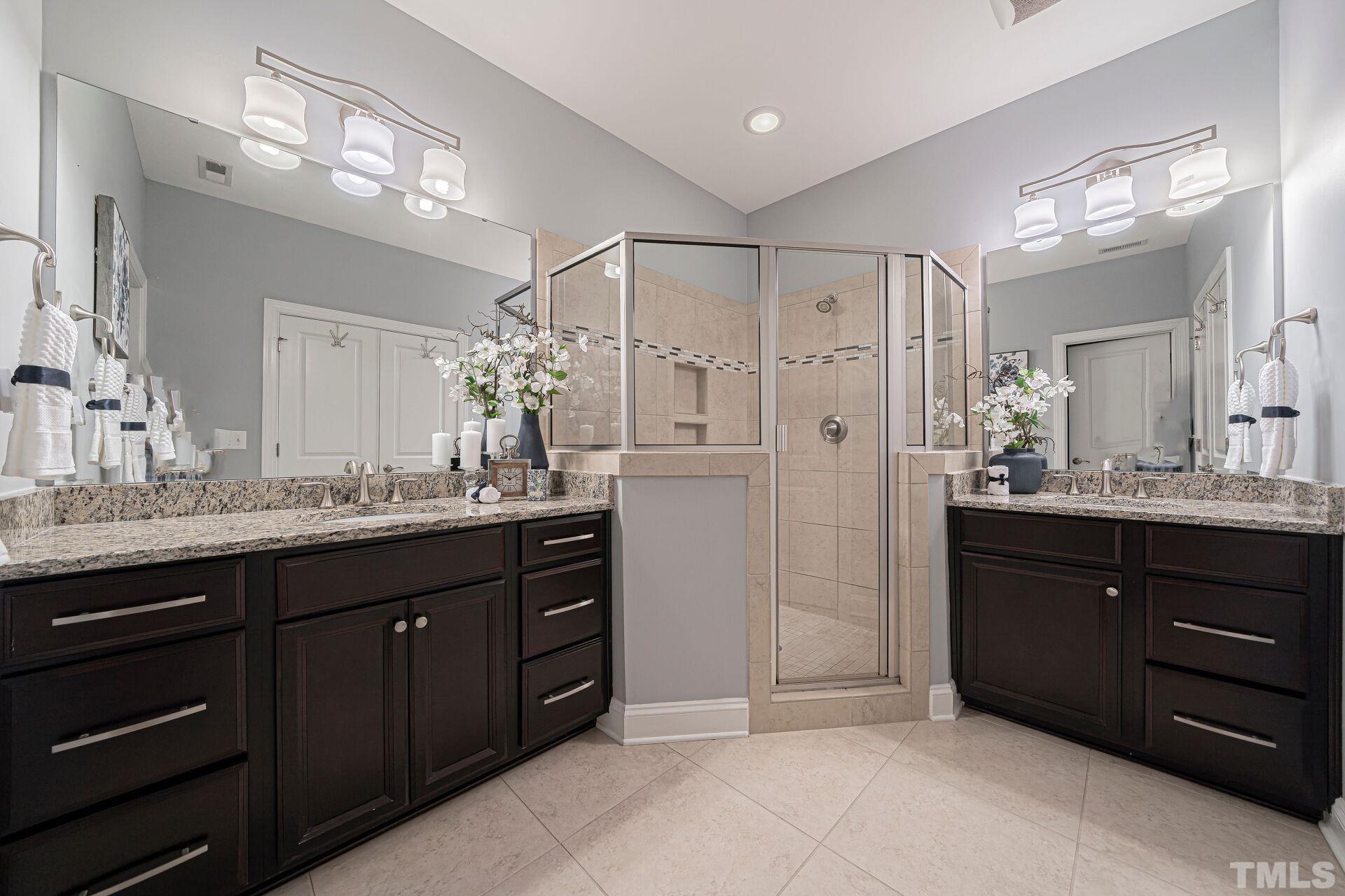3604 Winifred Way Raleigh, NC 27609 - Photo 12 of 19 a spacious bathroom with a granite countertop sink a mirror a vanity and a shower