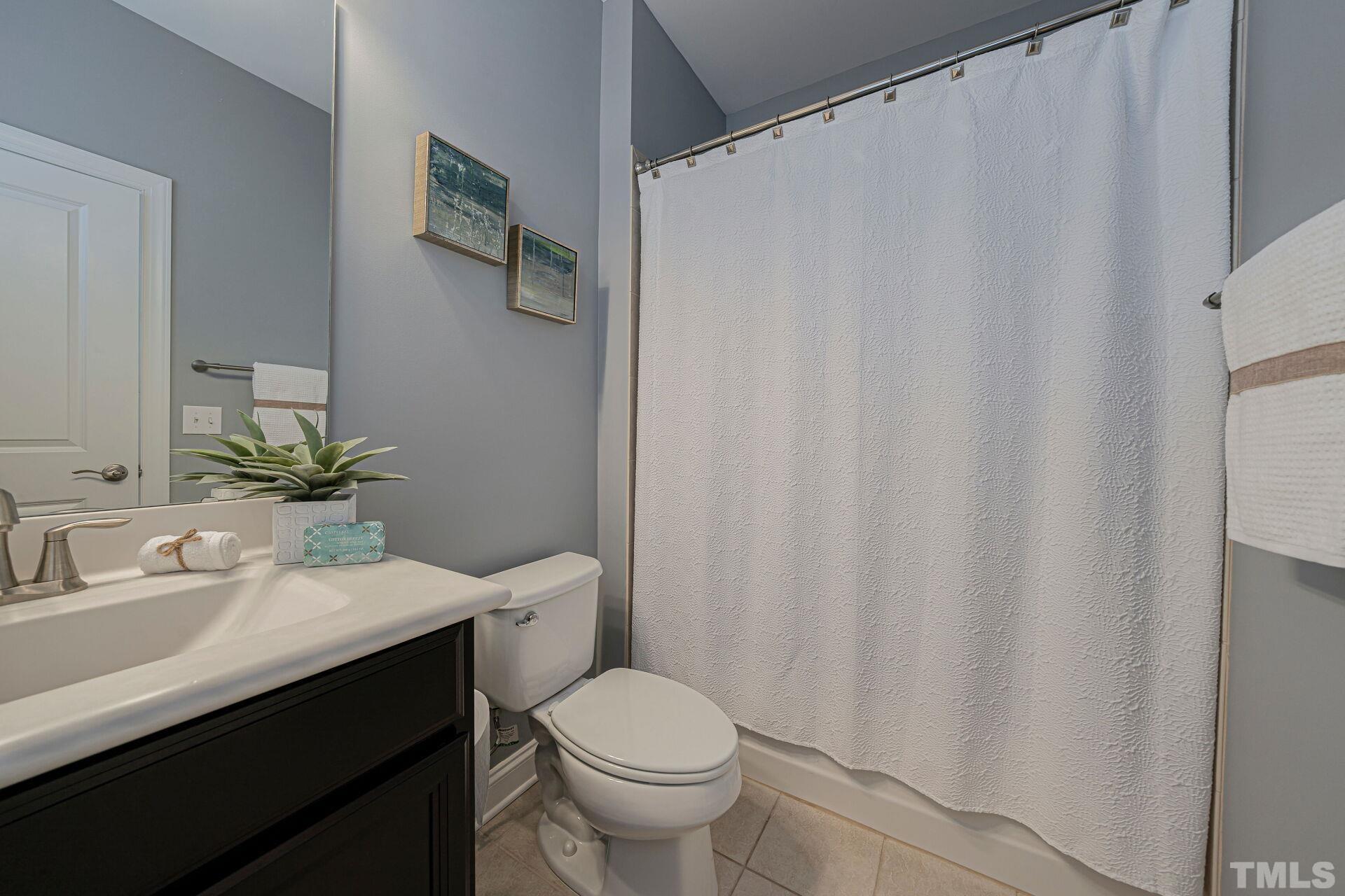 3604 Winifred Way Raleigh, NC 27609 - Photo 14 of 19 a bathroom with a sink a toilet and shower curtain