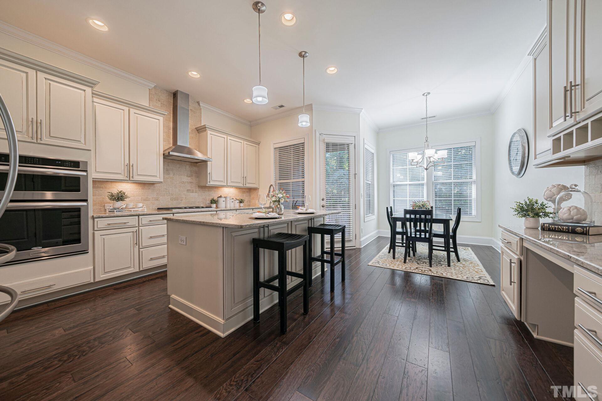 3604 Winifred Way Raleigh, NC 27609 - Photo 8 of 19 a kitchen with stainless steel appliances granite countertop wooden floors stove and white cabinets
