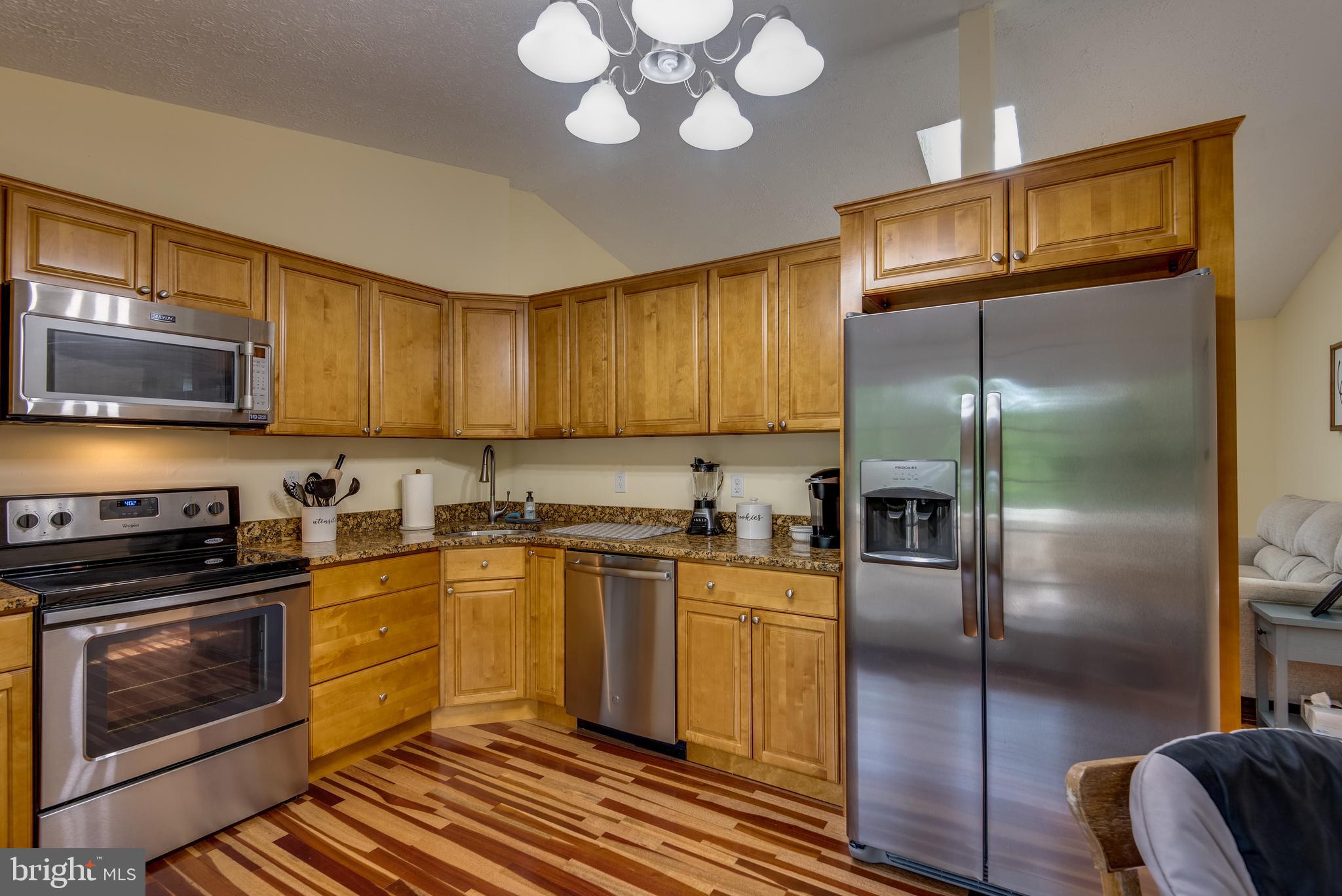12430 Ridge Road Lusby, MD 20657 - Photo 17 of 36 a kitchen with stainless steel appliances granite countertop a stove a sink and a refrigerator