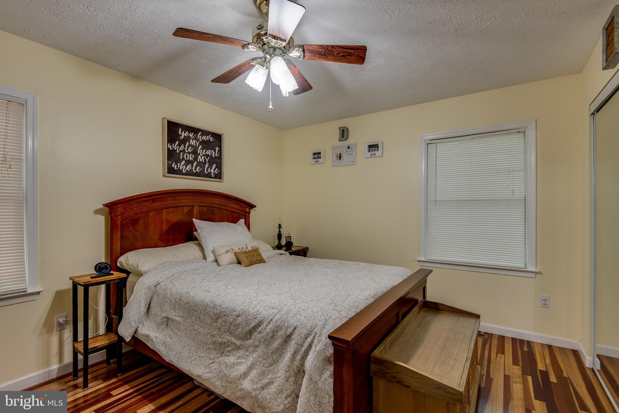 12430 Ridge Road Lusby, MD 20657 - Photo 22 of 36 a bedroom with a bed and a chandelier