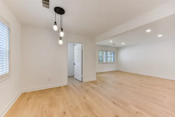 a view of an empty room and a chandelier fan