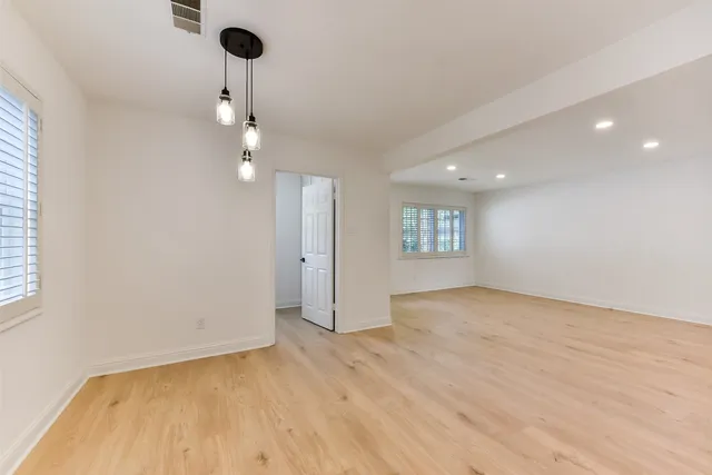 a view of an empty room and a chandelier fan